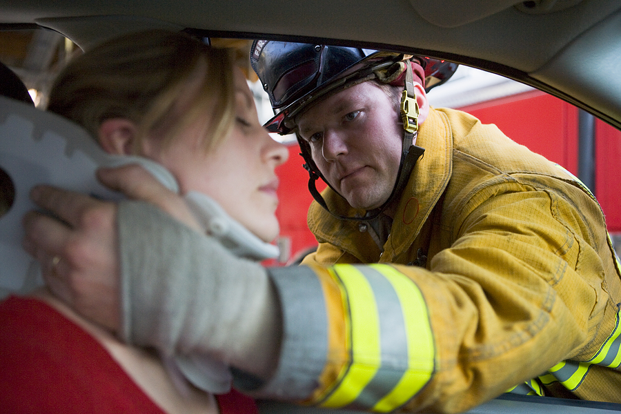 Firefighter wrapping someone's neck after an auto accident